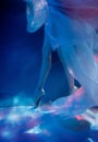 Ballerina dancing underwater in pointe and waved dress, soft blurred focus in water.
