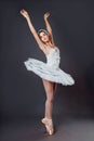 Ballerina dancing in white dress. Color photo. Graceful ballet dancer or classic ballerina dancing  on grey studio Royalty Free Stock Photo