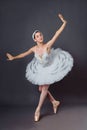 Ballerina dancing in white dress. Color photo. Graceful ballet dancer or classic ballerina dancing  on grey studio Royalty Free Stock Photo