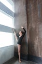 Ballerina doing aerobic exercise near sunlight window.