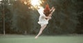 Ballerina jumps on lawn and trees background. Royalty Free Stock Photo