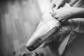 Ballerina laces the ribbons of the pointes. BW lifestile photo. close-up of legs