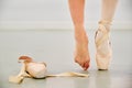 Ballerina legs wearing a pointe shoe on one foot and nothing on the other.