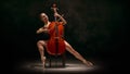 Ballerina performing cello part on pointe in dramatic stage light Royalty Free Stock Photo