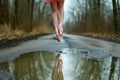 ballerina with pink shoes jumps over water puddle, midair