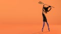 A ballerina on pointe shoes in a black witch costume in a hat and with a broom dances on an orange background