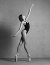 Ballerina in pointe shoes dancing in black clothes