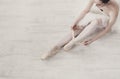 Ballerina puts on pointe ballet shoes, graceful legs Royalty Free Stock Photo