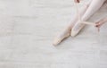 Ballerina puts on pointe ballet shoes, graceful legs Royalty Free Stock Photo