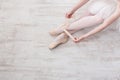 Ballerina puts on pointe ballet shoes, graceful legs Royalty Free Stock Photo