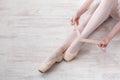 Ballerina puts on pointe ballet shoes, graceful legs