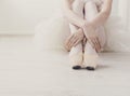 Ballerina puts on pointe ballet shoes, graceful legs Royalty Free Stock Photo