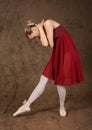 Ballerina red dress dance pose brown background Royalty Free Stock Photo