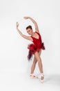 The ballerina in a red dress dances on a white backg Royalty Free Stock Photo