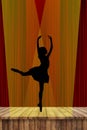 Ballerina silhouette of a young ballet lady dancing on pointe in attitude derriere position on stage in the spotlight with a red c Royalty Free Stock Photo