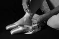 Ballerina sit down on floor to put on slippers Royalty Free Stock Photo