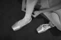 A ballerina, sitting on the floor, puts on the pointes Royalty Free Stock Photo