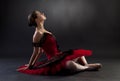 Ballerina sitting over black background