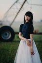 Ballerina stands in field on background of agricultural sprayer Royalty Free Stock Photo