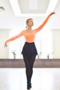 Ballerina stands on her fingertips and lift her hands. photo shoot in the dance studio on a white background