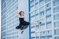 Ballerina in a tutu posing at a multi-storey residential building. A beautiful young woman wearing a black dress and wearing Royalty Free Stock Photo