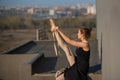 Ballerina in a tutu posing near the fence. Beautiful young woman wearing a black dress and wearing pointe shoes outside Royalty Free Stock Photo