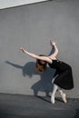 Ballerina in tutu posing standing near the wall. Beautiful young woman in black dress and pointe dancing outside Royalty Free Stock Photo