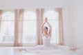 A ballerina on a twine in white clothes in a white studio. Royalty Free Stock Photo