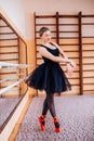 Ballerina Wearing black Tutu Doing exercise in training hall. Royalty Free Stock Photo