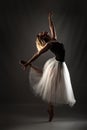 Ballerina with a white dress and black top posing on gray background Royalty Free Stock Photo