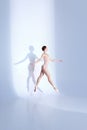 Ballet Beauty. Body-Size Portrait of athlete young woman showcases balletic prowess in pink sport swimsuit and pointe