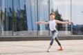Ballet boy teenager dancing against the background of reflection of the city and sky in the glass wall Royalty Free Stock Photo