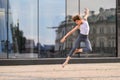 Ballet boy teenager dancing against the background of reflection of the city and sky in the glass wall Royalty Free Stock Photo