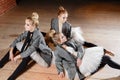 The ballet concept. Young ballerina girls relax sitting on the floor. Women at the rehearsal in a white tutu and a grey