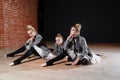 The ballet concept. Young ballerina girls relax sitting on the floor. Women at the rehearsal in a white tutu and a grey