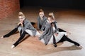 The ballet concept. Young ballerina girls relax sitting on the floor. Women at the rehearsal in a white tutu and a grey