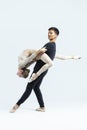 Ballet Concepts. Asian Young Man and Caucasian Woman Performing As Ballet Dancers Over Grey Studio Backdrop During Suppots As Royalty Free Stock Photo