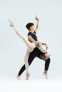 Ballet Concepts. Asian Young Man and Caucasian Woman Performing As Ballet Dancers Over Grey in Studio During Suppots As Classical Royalty Free Stock Photo