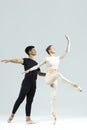 Ballet Concepts. Asian Young Man and Caucasian Woman Performing As Ballet Dancers Over Grey Studio Background Doing Suppots Royalty Free Stock Photo