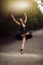 Ballet Dance Concepts. Slim Passionate Young Japanese Ballet Dancer in Black Tutu Posing During Ballet Pas in Summer Forest With