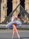 Ballet dancer dancing in front of the famous Louvre Museum