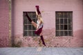 Ballet dancer girl jump on street in front of pink wall Royalty Free Stock Photo