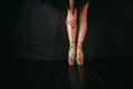 Ballet dancer legs in pointes, black wooden floor Royalty Free Stock Photo