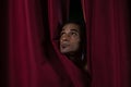 Ballet dancer peeking through a stage curtain Royalty Free Stock Photo