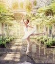 Ballet dancer posing in green botanical garden