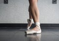 Ballet dancer showing off her pointe shoes standing in classical position Royalty Free Stock Photo