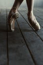 Ballet dancer stretching on tiptoes in the black studio