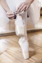 Ballet dancer tying slippers around her ankle Royalty Free Stock Photo