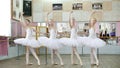 in ballet hall, girls in white ballet skirts are engaged at ballet, rehearse tendue forward battement, Young ballerinas Royalty Free Stock Photo