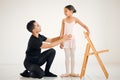 Ballet has instilled so much confidence in her. a ballet teacher assisting a student with her position in a dance studio
